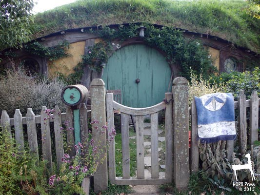 Hobbit house with front gate and picket fence.
