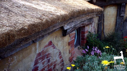 Thatched roof and brick-plaster wall of Hobbit house.
