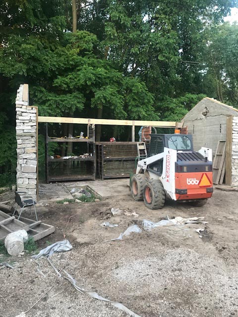 The barn features stone walls on both ends with connecting beams between them.