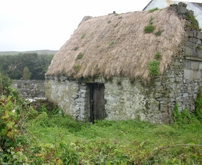 Irish stone building with a thatched roof.